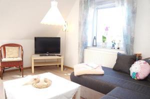 a living room with a couch and a tv at Pirk in Norden