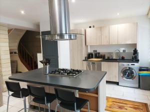 uma cozinha com uma ilha e um forno com placa de fogão em Agréable maison de ville tout confort em Loudun