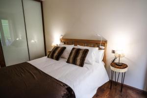 um quarto com uma cama branca e 2 almofadas em Apartamento Luxury en Bordes d'Envalira, Andorra em Soldeu