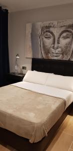 sypialnia z dużym łóżkiem i obrazem na ścianie w obiekcie Apartamento Miguel Angel w mieście Conil de la Frontera +4 zdjęcia
