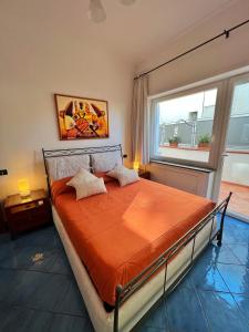 ein Schlafzimmer mit einem Bett mit einer orangefarbenen Bettdecke in der Unterkunft Augusto Capri Apartment in Capri