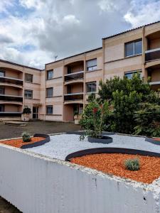 an apartment building with a garden in front of it at Le Champollion - Clim - Gare - Garage - Balcon in Albi