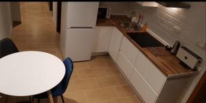 małą kuchnię ze stołem i białą lodówką w obiekcie Apartamento Miguel Angel w mieście Conil de la Frontera