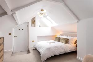 1 dormitorio con cama blanca y techo en Luxe Design - Boutique Apartment - Heart of Rothbury, en Rothbury