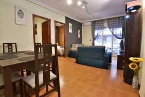 a living room with a table and a blue couch at Apartamento Gregorio in Torrevieja
