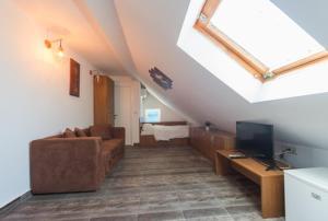 a living room with a couch and a tv at Vila Troia Vama Veche in Vama Veche