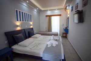 a hotel room with two beds with towels on them at Villa Bel Passo Apartments in Kefalos