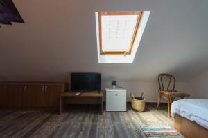 a bedroom with a bed and a tv and a window at Vila Troia Vama Veche in Vama Veche +34 photos