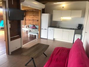 ein Wohnzimmer mit einem Tisch und einer Küche in der Unterkunft Maison Ste Anne/Marin Piscine personnelle vue sur mer in Le Marin