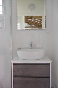 W łazience znajduje się umywalka i lustro. w obiekcie Maison Ste Anne/Marin Piscine personnelle vue sur mer w mieście Le Marin