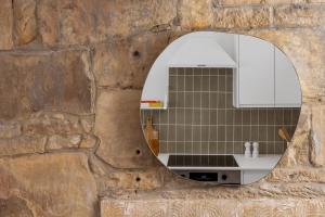 a kitchen with a mirror on a stone wall at Luxe Design - Boutique Apartment - Heart of Rothbury in Rothbury