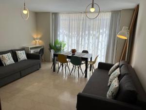 ein Wohnzimmer mit einem Sofa und einem Tisch in der Unterkunft Gran Apartamento grupo familiar, amigos o trabajo in Málaga