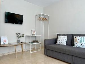 ein Wohnzimmer mit einem Sofa und einem Tisch in der Unterkunft Gran Apartamento grupo familiar, amigos o trabajo in Málaga