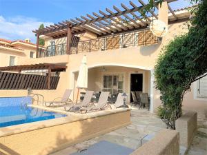 a villa with a swimming pool and a house at Villa Anastasia ,150 m to Coral Bay beach in Peyia