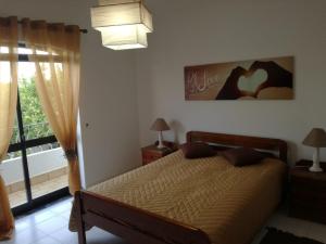 a bedroom with a bed and a window at Vivenda Bemposta in Alvor