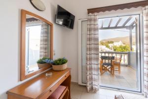 a room with a table and a mirror and a balcony at Tassos Apartments I in Alinda