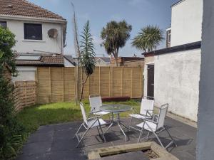 un patio con mesa, sillas y una valla en 33 Valentia place, en Newcastle