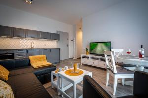 Televízia a/alebo spoločenská miestnosť v ubytovaní Apartamenty Ustronne Liściasta