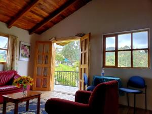 a living room with a door open to a porch at Hosteria Rose Cottage in Otavalo