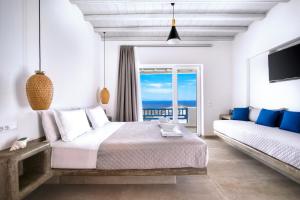 a bedroom with a bed and a view of the ocean at Anius Apartments in Mikonos