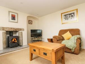 a living room with a couch and a fireplace at Withan Farm Wing in Manaccan