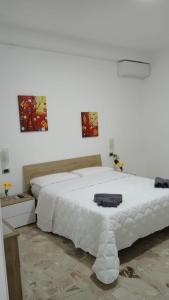 Un dormitorio blanco con una gran cama blanca. en CHIARANTO, en Menfi