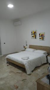 1 dormitorio con 1 cama blanca grande en una habitación en CHIARANTO, en Menfi