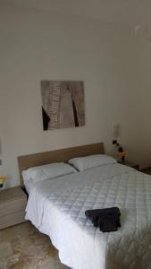 um quarto com uma grande cama branca e uma imagem na parede em CHIARANTO em Menfi