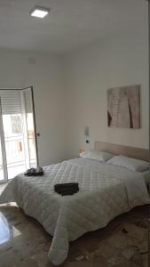 um quarto branco com uma cama grande e uma imagem na parede em CHIARANTO em Menfi
