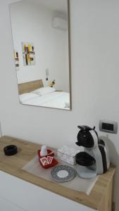 um espelho em cima de uma prateleira de madeira com uma chaleira para chá em CHIARANTO em Menfi