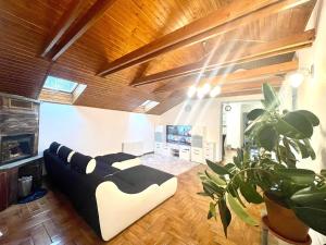 a living room with a black and white couch at Holiday home with Jakuzzi and Sauna in Kisoroszi