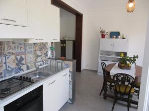 a kitchen with a sink and a table at Le Case Di Tufo- Casa del sole in Favignana
