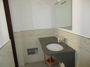 a bathroom with a sink and a mirror at Le Case Di Tufo- Casa del sole in Favignana +1 photo