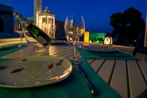 a table with a plate and a bottle of wine at Folia Apartments in Fira