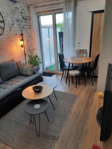 uma sala de estar com um sofá e mesas em Le MAGDAD em Rochefort