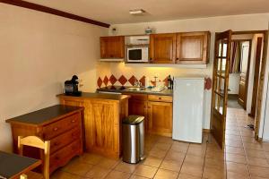 a kitchen with wooden cabinets and a white refrigerator at Apartment Of 55 M With Balcony View Mont Blanc in Chamonix