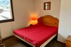 a red bed in a small room with a window at Apartment Of 55 M With Balcony View Mont Blanc in Chamonix