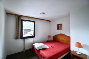 a bedroom with a red bed and a window at Apartment Of 55 M With Balcony View Mont Blanc in Chamonix