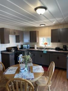 a kitchen with a wooden table with chairs and a tableasteryasteryasteryasteryastery at Cozy Lake Cabin Dock boat slip and lily pad in Lake Ozark