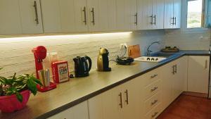 a kitchen with white cabinets and a counter top at Sugarstone House in Adamas