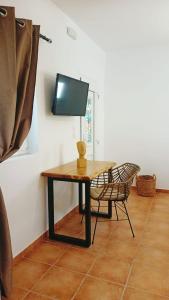 a table with a chair and a television on a wall at Sugarstone House in Adamas +24 photos