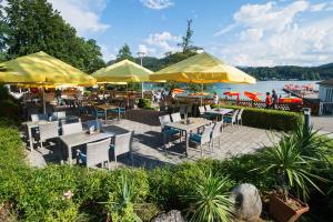 a restaurant with tables and chairs and yellow umbrellas at Terrassenhotel Reichmann in Sankt Kanzian