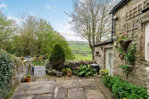 uma casa de pedra com um jardim em frente em Brown Hill Cottage em Feetham