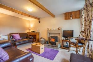uma sala de estar com um sofá e uma lareira em Brown Hill Cottage em Feetham
