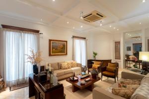 uma sala de estar com um sofá e uma mesa em Maison Neoclássica 5 estrelas confort em Ribeirão Preto