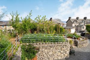 einen Garten mit einer Steinmauer und einigen Pflanzen in der Unterkunft Hillberry in Grange Over Sands