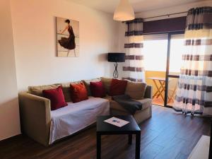 ein Wohnzimmer mit einem Sofa und einem Tisch in der Unterkunft Sunrise Apartment 3BR (Free Wi-Fi) in Peniche