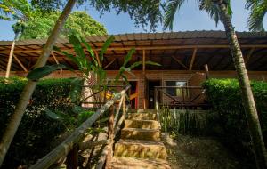 dom ze schodami prowadzącymi do niego w obiekcie Suites La Tortuga w mieście Ayampe