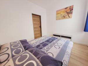 a bedroom with a bed and a picture on the wall at Apartamenty Morski Brzeg - Sauna, Balia in Władysławowo +16 photos