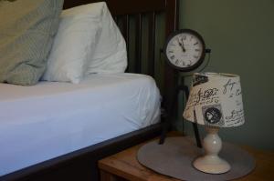 a bedroom with a bed and a clock and a lamp at Penzion Pohoda Sokolov in Sokolov